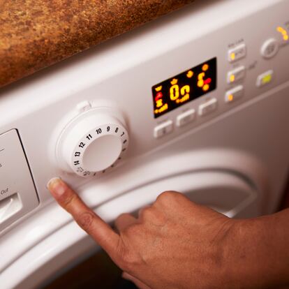 woman using washing machine, London, UK