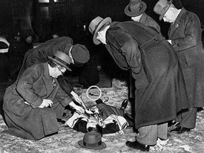 La policía examina el cadáver de Louis Cohen, asesino de Kid Dropper. Fotografía del <i>Daily News</i> de Nueva York, publicada en 1939, en la exposición del Museo Judío de Viena.