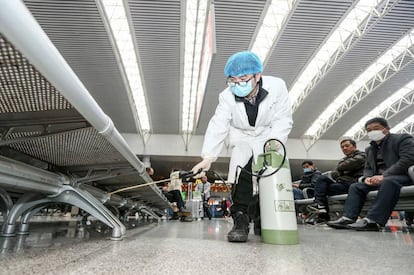 Esta foto tomada el 22 de enero de 2020 muestra a los miembros del personal desinfectando en la estación de tren Yingtan North en Nanchang, en la provincia central de Jiangxi de China.