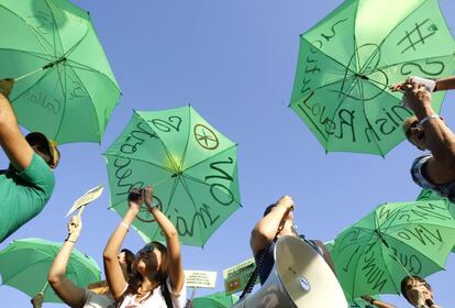 Coreando consignas contra los bancos, la globalizaci&oacute;n y los pol&iacute;ticos, y con mensajes escritos en paraguas para hacerlos bien visibles mientras tambi&eacute;n alivian el calor del sol.