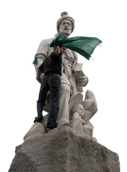 Un partidario de Musaví intenta colocar una bufanda verde, el color de los opositores, a la estatua del poeta Abulgasem Ferdusi en Teherán.