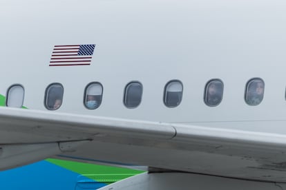 Migrantes provenientes de Estados Unidos observan por la ventana de un avión este jueves, a su llegada al Aeropuerto Internacional Juan Santamaría, en San José (Costa Rica).