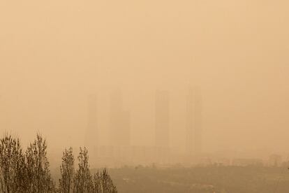 Vista de las Cuatro Torres de Madrid desde las afueras de Madrid. La capital se ha despertado la mañana de hoy con un fenómeno meteorológico inusual generado por una elevada cantidad de polvo en suspensión proveniente del Sáhara.