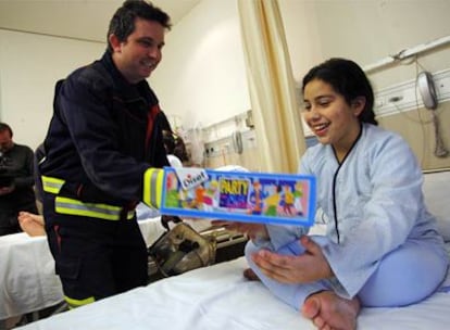 Kaltuma, de 11 años, recibe la visita de los bomberos en el hospital Gregorio Marañón.