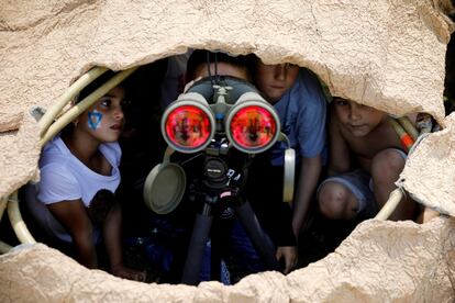 Niños israelíes observan a través de unos binoculares durante una exhibición de equipos y habilidades de las Fuerzas de Defensa Israelíes, en Sderot, Israel.