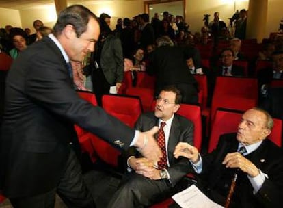 José Bono (de pie) saluda a Manuel Fraga, en presencia de Mariano Rajoy, en el homenaje póstumo que se le rindió ayer a Rogelio Baón.