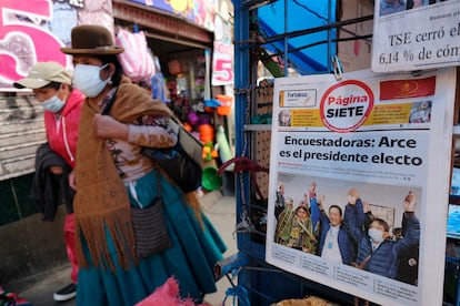 Una mujer camina en La Paz delante de la portada de un diario que anuncia el triunfo de Luis Arce en las elecciones del pasado domingo.