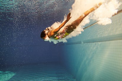 Una mujer nada en una piscina. 