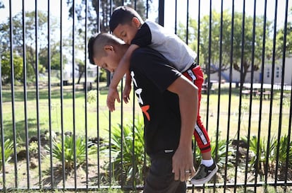 Un padre lleva a la espalda a su hijo de seis años en Oakland (California).