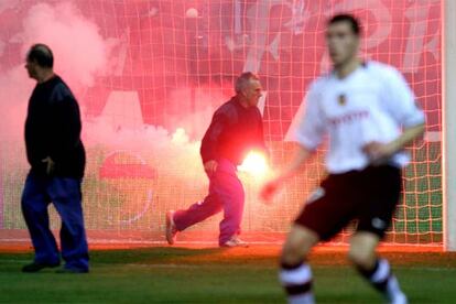 Empleados del Atlético retiran el pasado domingo las bengalas del césped del Calderón.