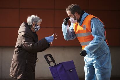 Protección Civil de Pamplona reparte mascarillas a personas en centros de salud y paradas de autobús durante la crisis del coronavirus, este martes en Pamplona.