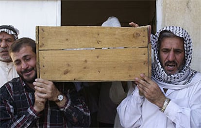Los familiares de una de las víctimas de Baquba llevan a hombros el féretro hacia el cementerio.