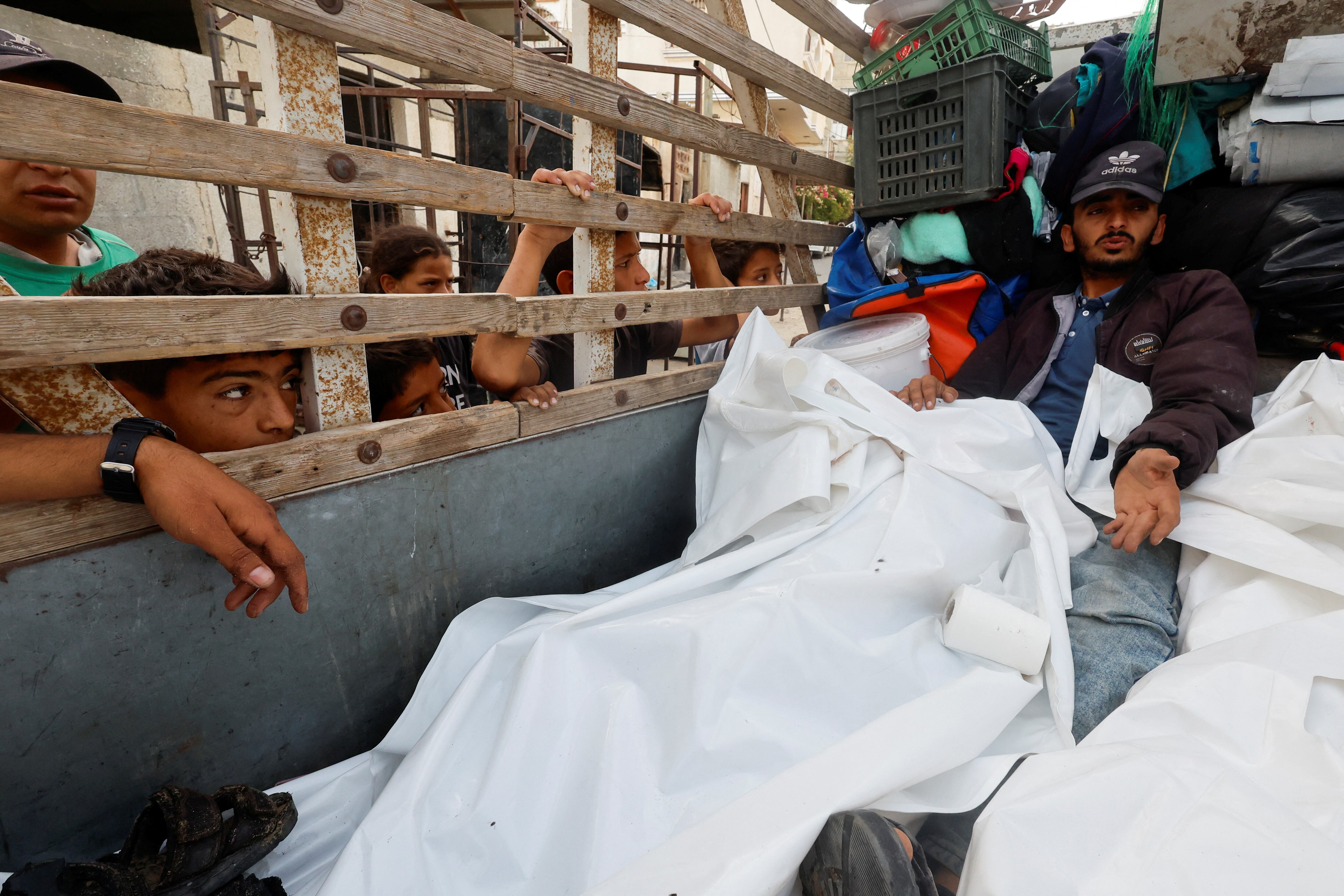 Un hombre permanece junto a los cadáveres de varias personas muertas tras un ataque israelí sobre un campo de desplazados en Rafah, durante su funeral este lunes.  