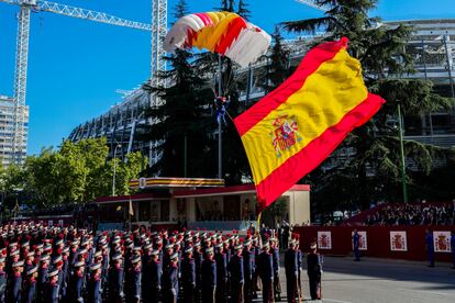 Un paracaidista aterriza con la bandera de España en la Plaza de Cuzco, al inicio de los actos del 12 de octubre. 