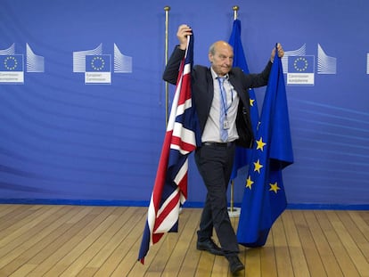 Un responsable de protocolo de la UE sostiene en Bruselas las banderas de Reino Unido y la UE, en una imagen de 2017.