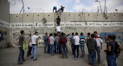 Palestinos saltan el muro de separación para ir a rezar a Jerusalén.