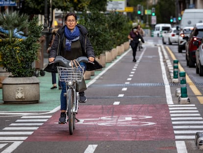 Una mujer circula por un carril bici protegido en Valencia.