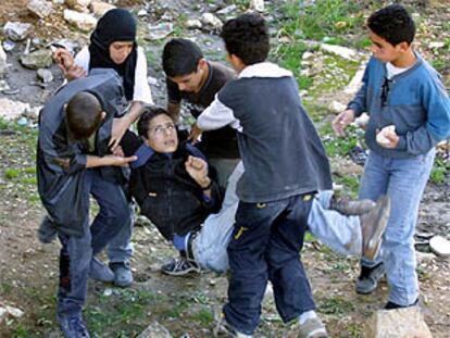 Varios niños evacuan a un amigo herido mientras lanzaban piedras contra soldados israelíes en Belén.