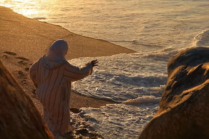 Esta mujer tradicional parece abducida o, cuanto menos, maravillada ante la visión del océano Atlántico en plena luz de atardecer, parece querer atrapar la mar con su mano desde la distancia, Se trata de la playa de Rabat en un día festivo cualquiera fuera de temporada.