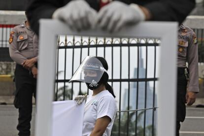 Una activista durante una protesta frente al parlamento en Yakarta (Indonesia). El presidente de Indonesia, Joko Widodo, ha insistido en aumentar un 50% la capacidad de realizar test diarios de la covid-19 después de que el país, el más afectado por la pandemia del sureste asiático, superase los 75.000 casos de coronavirus.