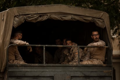 Efectivos del Ejército de Tierra, en el interior de un camión militar en Paiporta este domingo. 

