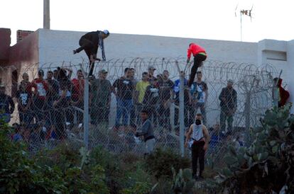 Un grupo de jóvenes marroquíes saltan la valla marroquí que separa Marruecos de la valla española en Melilla, este viernes.