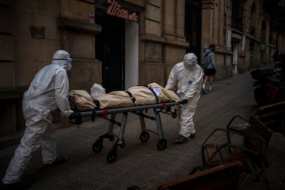 Empleados de una funeraria trasladan el cadáver de un anciano fallecido por covid en una residencia de Barcelona, el 13 de noviembre.