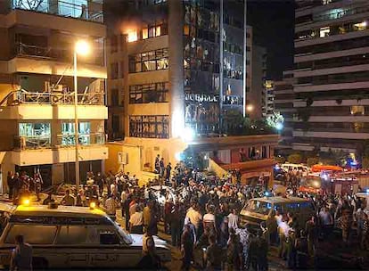 Policías, miembros de los equipos de rescate y residentes observan los daños causados por una bomba anoche en el barrio de Verdún, en Beirut.