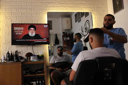 Varias personas en una barbería observaban por televisión la intervención de Hasan Nasrallah, líder de Hezbolá, este viernes en Beirut (Líbano).