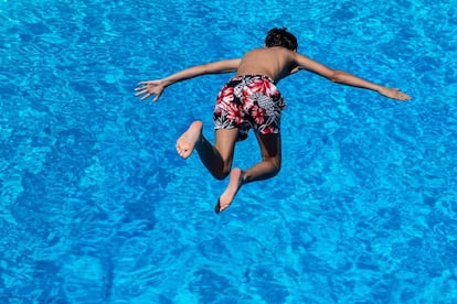 Un niño salta desde un trampolín a una piscina en Goettingen, Alemania, el 25 de junio de 2019. 