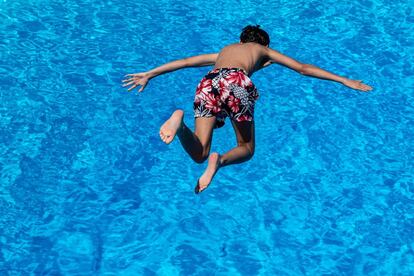 Un niño salta desde un trampolín a una piscina en Goettingen, Alemania, el 25 de junio de 2019.