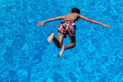 Un niño salta desde un trampolín a una piscina en Goettingen, Alemania, el 25 de junio de 2019. 