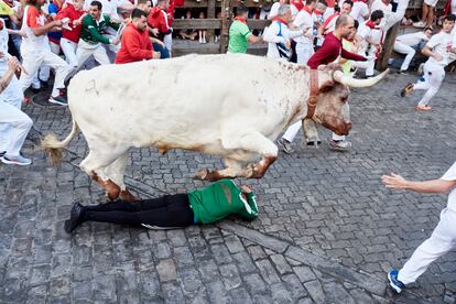 Un cabestro salta por encima de un corredor durante el primer encierro de los Sanfermines. 