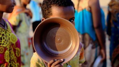 Un niño etíope, que ha huido de la guerra en la región de Tigray, lleva su plato mientras hace cola para obtener raciones de comida en el campamento de Um-Rakoba, en la frontera entre Sudán y Etiopía en el estado de Al-Qadarif, Sudán, el pasado 19 de noviembre de 2020.