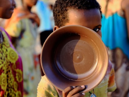 Un niño etíope, que ha huido de la guerra en la región de Tigray, lleva su plato mientras hace cola para obtener raciones de comida en el campamento de Um-Rakoba, en la frontera entre Sudán y Etiopía en el estado de Al-Qadarif, Sudán, el pasado 19 de noviembre de 2020.