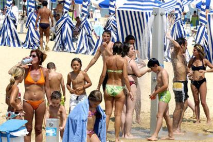 Numerosos bañistas se duchan en la playa de Ondarreta de San Sebastian, donde las temperaturas han superado los 35 grados.