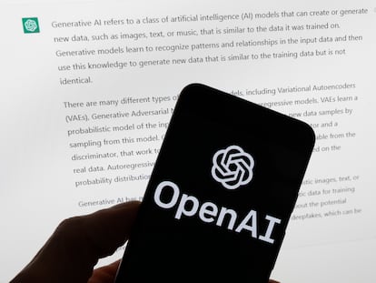 Un móvil con el logo de OpenAI, empresa desarrolladora de ChatGPT, frente a una pantalla con una respuesta aportada por la herramienta.