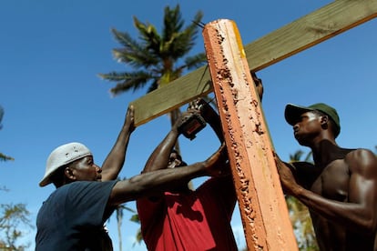 Tres personas trabajan en la reconstrucción de un negocio destruido por el paso del huracán María, en Loiza (Puerto Rico).