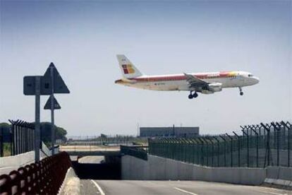 Un avión de Iberia aterriza en el aeropuerto de El Prat, en los terrenos de la tercera pista.