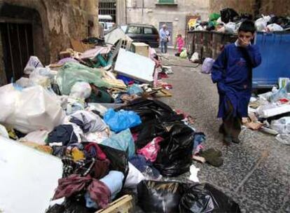 Un niño atraviesa una calle de Nápoles llena de basura.
