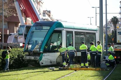 Empleados de TRAM trabajan para enderezar el convoy descarrillado.