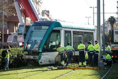 Empleados de TRAM trabajan para enderezar el convoy descarrillado. 