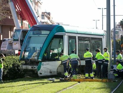 Empleados de TRAM trabajan para enderezar el convoy descarrillado. 