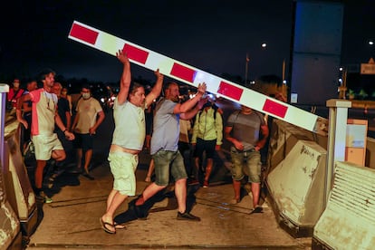 People lifting the toll barriers on the C-32 road.