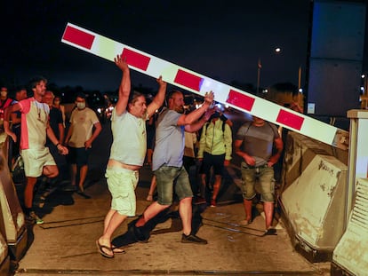 People lifting the toll barriers on the C-32 road.