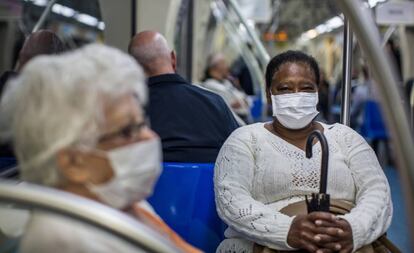 Dos pasajeras del metro de São Paulo se protegen con mascarillas.