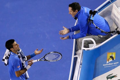 Novak Djokovic of Serbia, left, talks with chair umpire Jake Garner of the U.S. as he plays Andy Murray of Britain during the men's singles final at the Australian Open tennis championship in Melbourne, Australia, Sunday, Feb. 1, 2015.