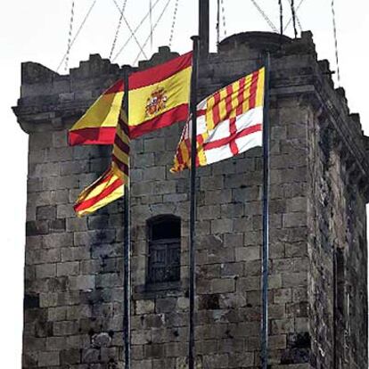 Las banderas española, catalana y de Barcelona, en lo alto del castillo de Montjuïc.