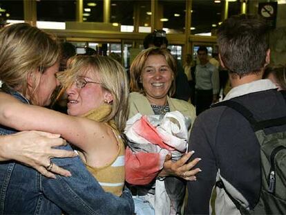 Algunos de los turistas españoles afectados por el huracán Wilma en México saludan a sus familiares en el aeropuerto de Barajas.