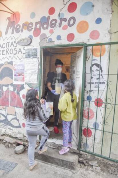 El merendero de las tacitas poderosas reparte alimento a dos niñas del barrio.